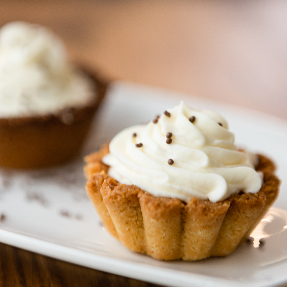 Two mini tarts on a white plate.