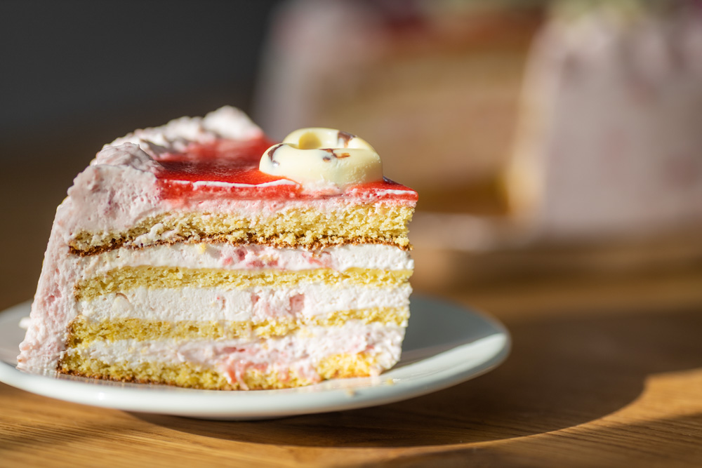 A slice of cake with layers on a white plate.