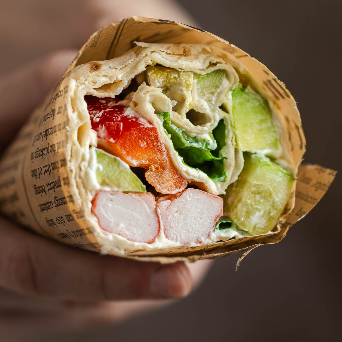 A lavash roll wrap held in a hand.
