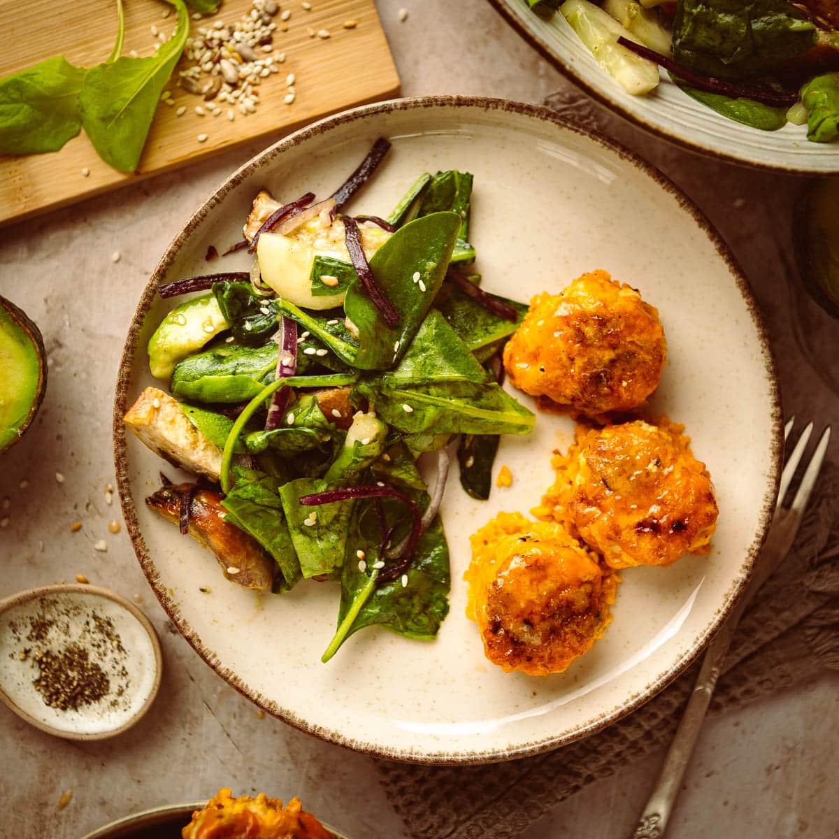 Gluten free chicken meatballs served on a plate along with green salad.