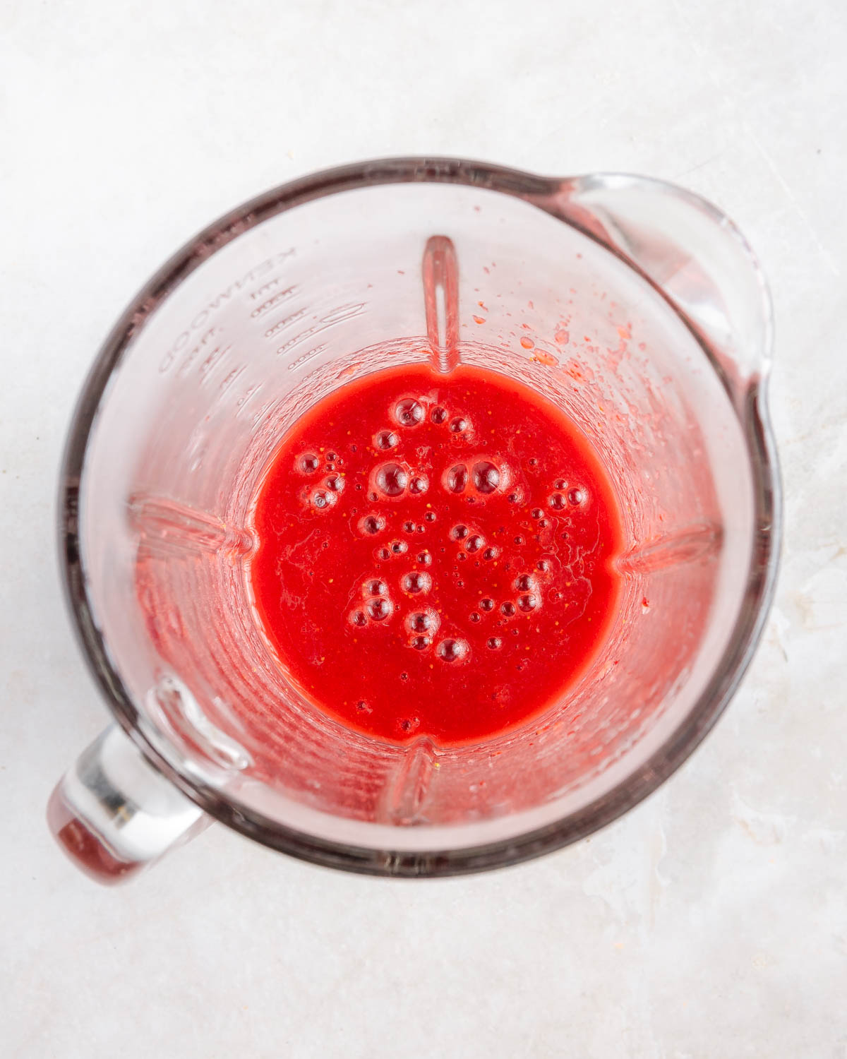 Blended strawberries in a blender, view from above.