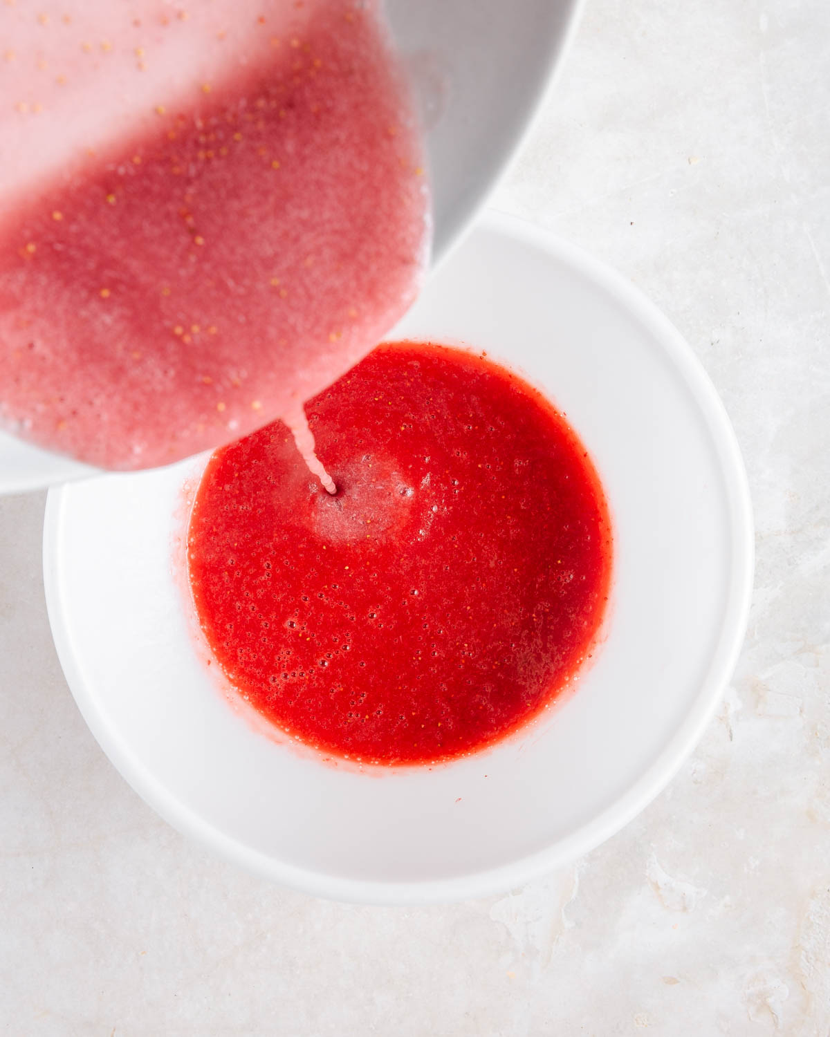 Gelatin being added to blended strawberries.