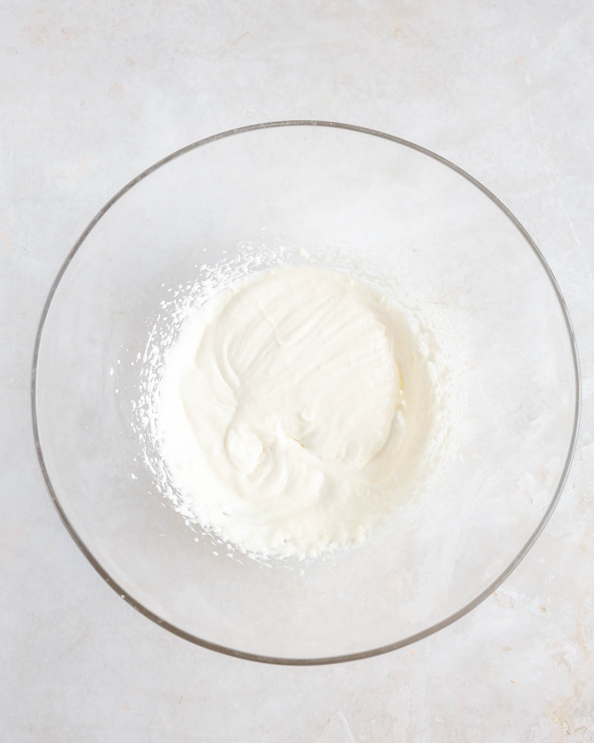 A clear bowl with mixed cream cheese and sweetener inside.