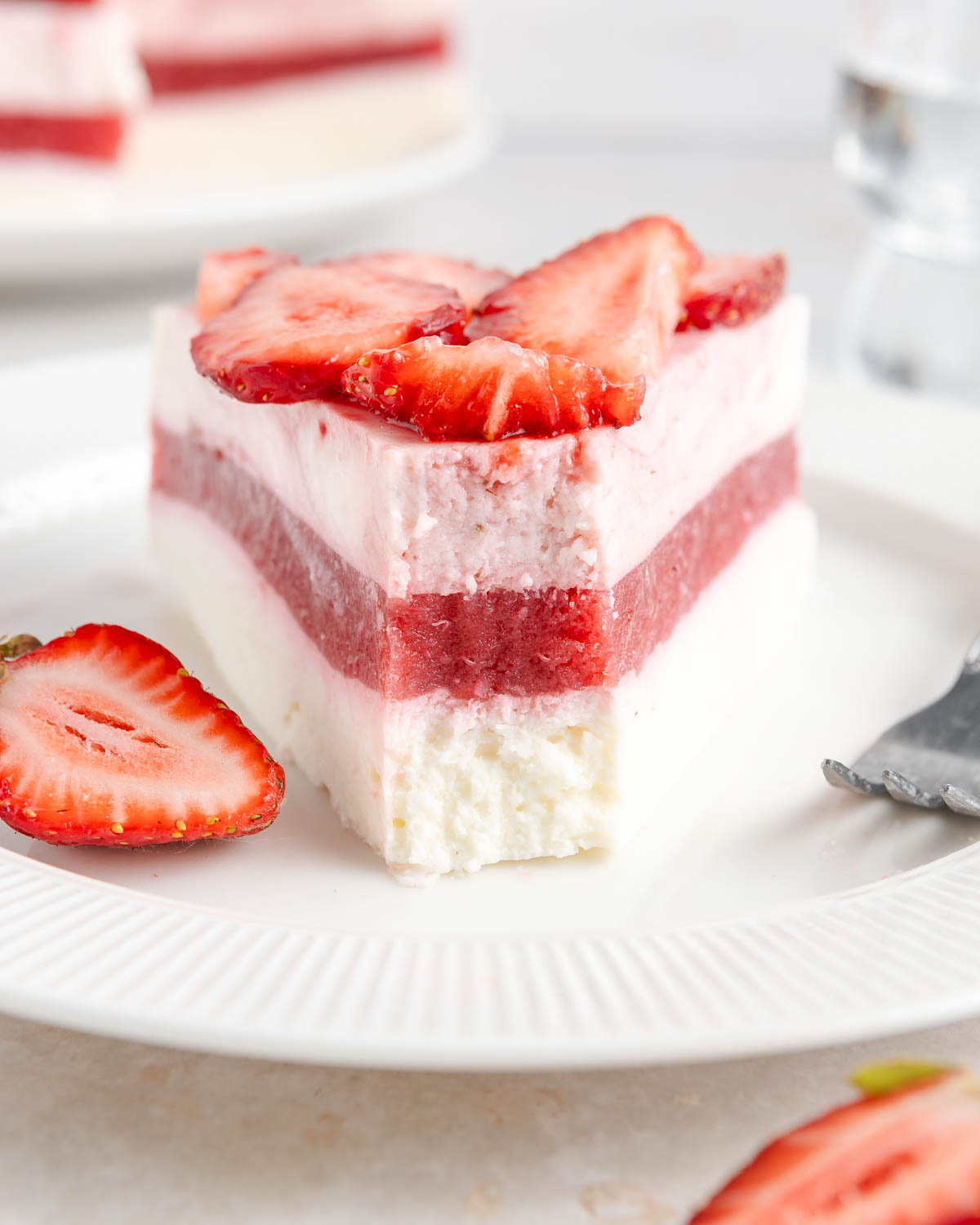 A straight-on shot of a slice of a strawberry cake with clear layers visible.
