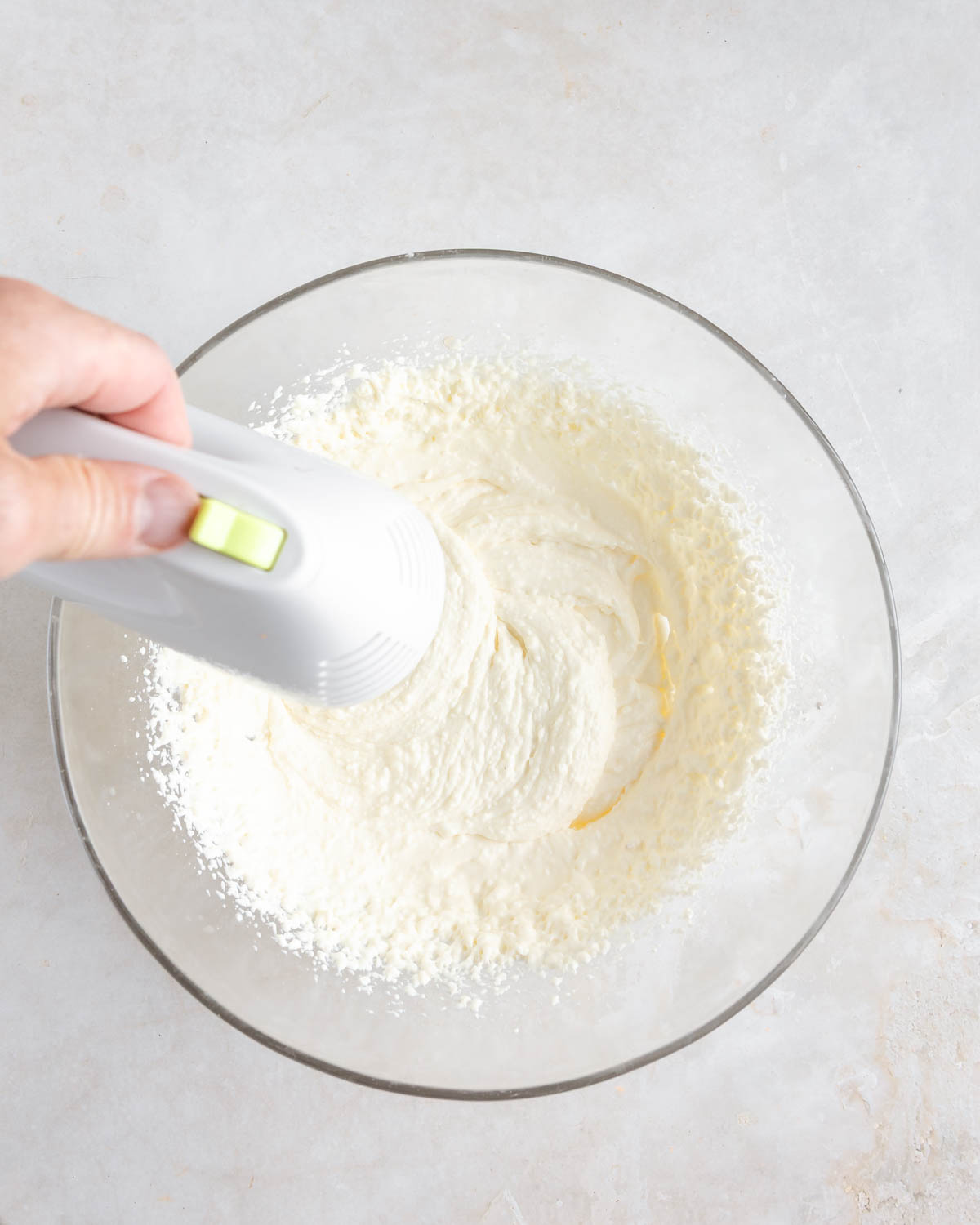 Cream cheese mixture being made using a hand-held mixer.