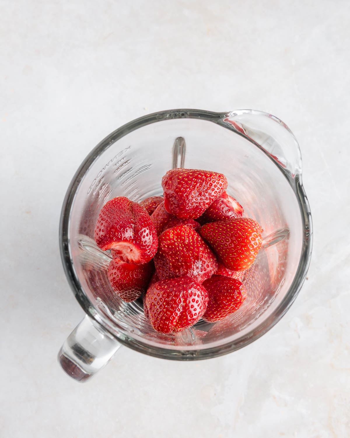 Whole fresh strawberries in a blending container.