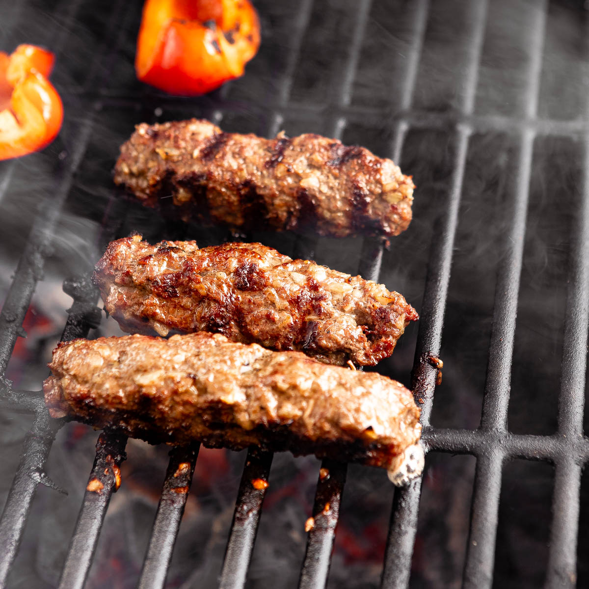Beef kebabs being grilled on an outdoor grill.