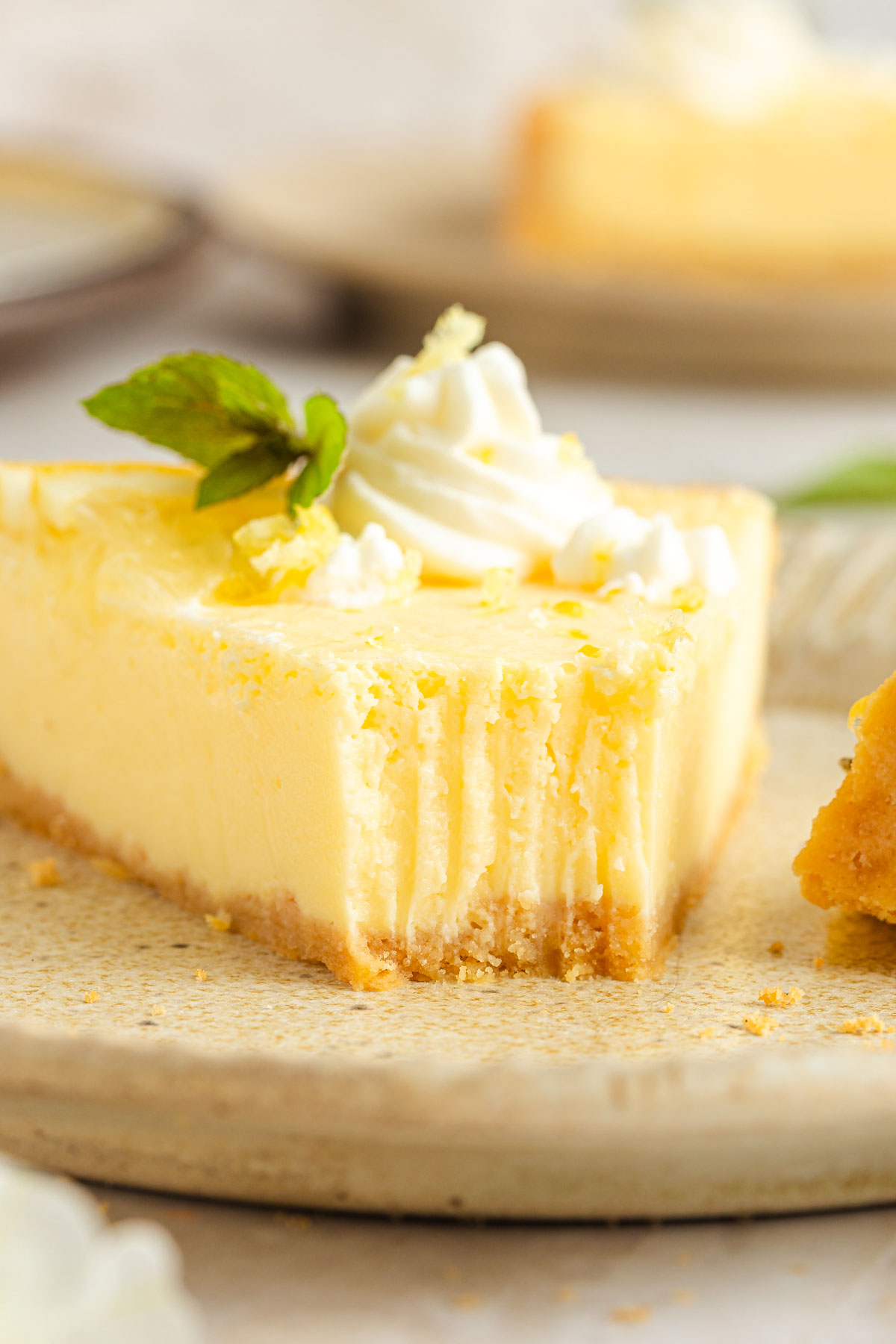 A closeup shot of a lemon tart slice with fork traces on the front.