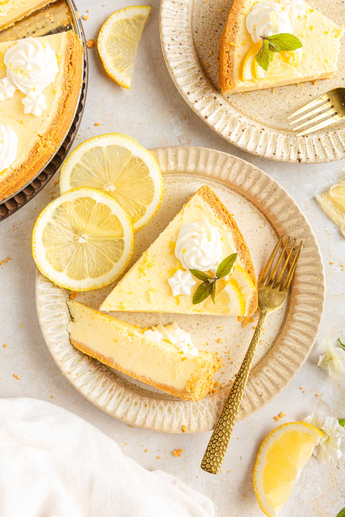 An overhead shot of lemon tart served on several plates, with lemon slices on the side.