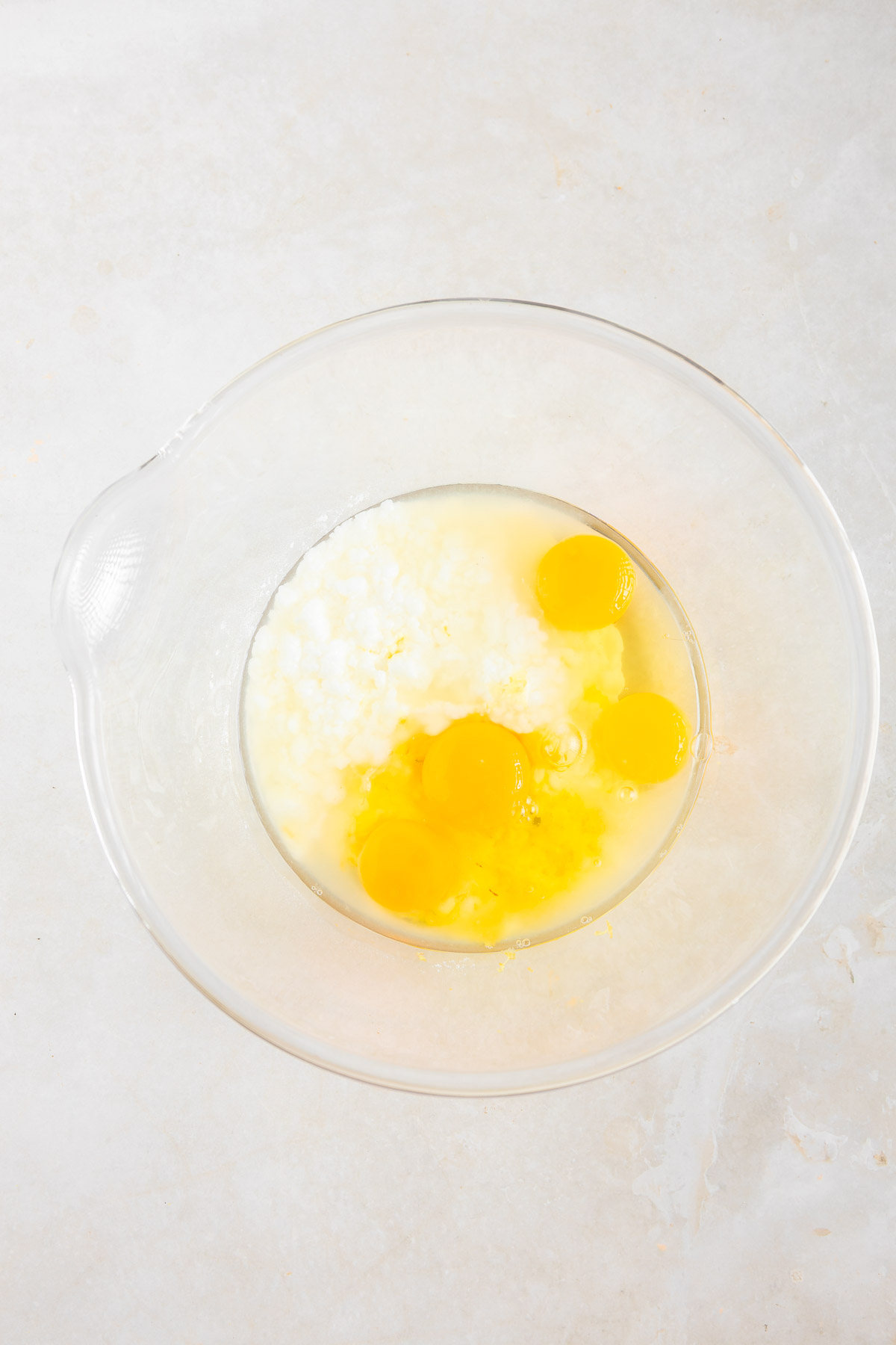 Lemon tart filling ingredients in a transparent bowl.