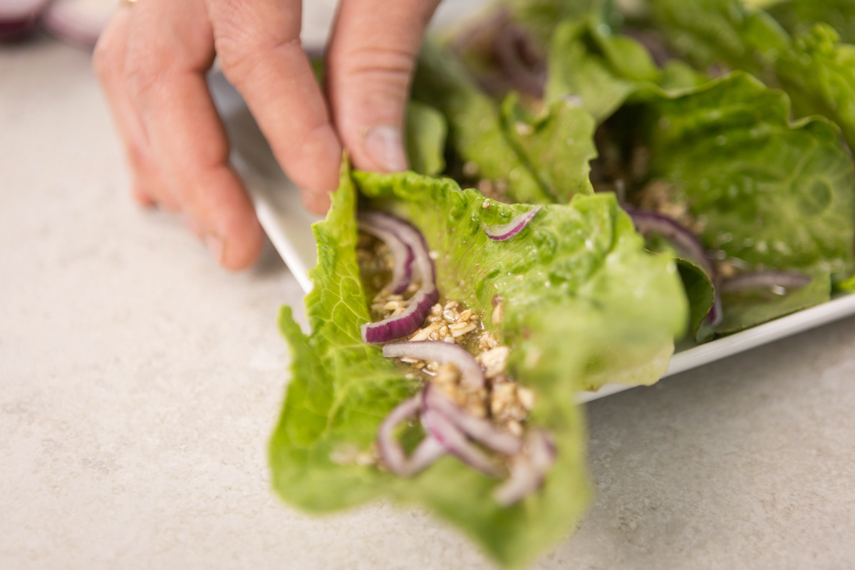 Lettuce salad with a hand picking it up.