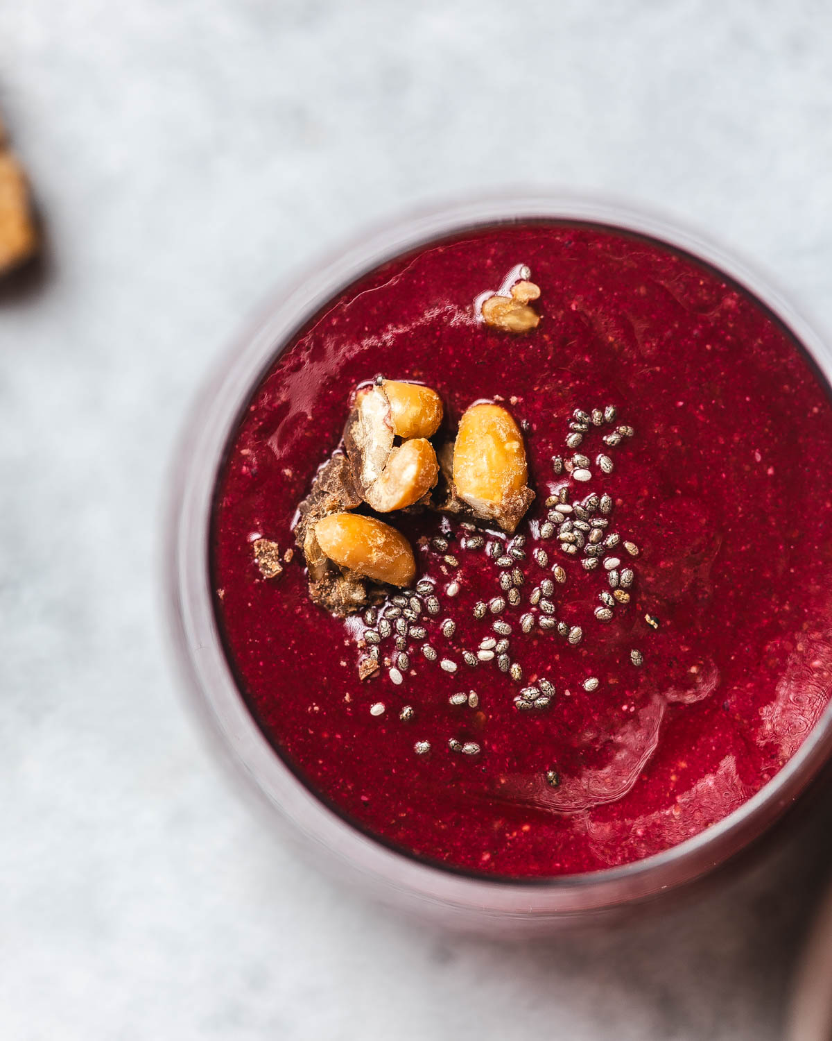 View from above onto a glass filled with vividly red beetroot and strawberry smoothie.