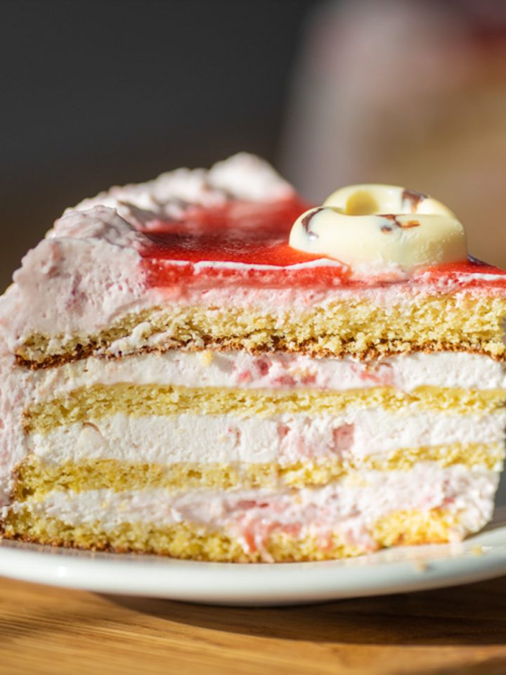 A slice of cake with layers on a white plate.
