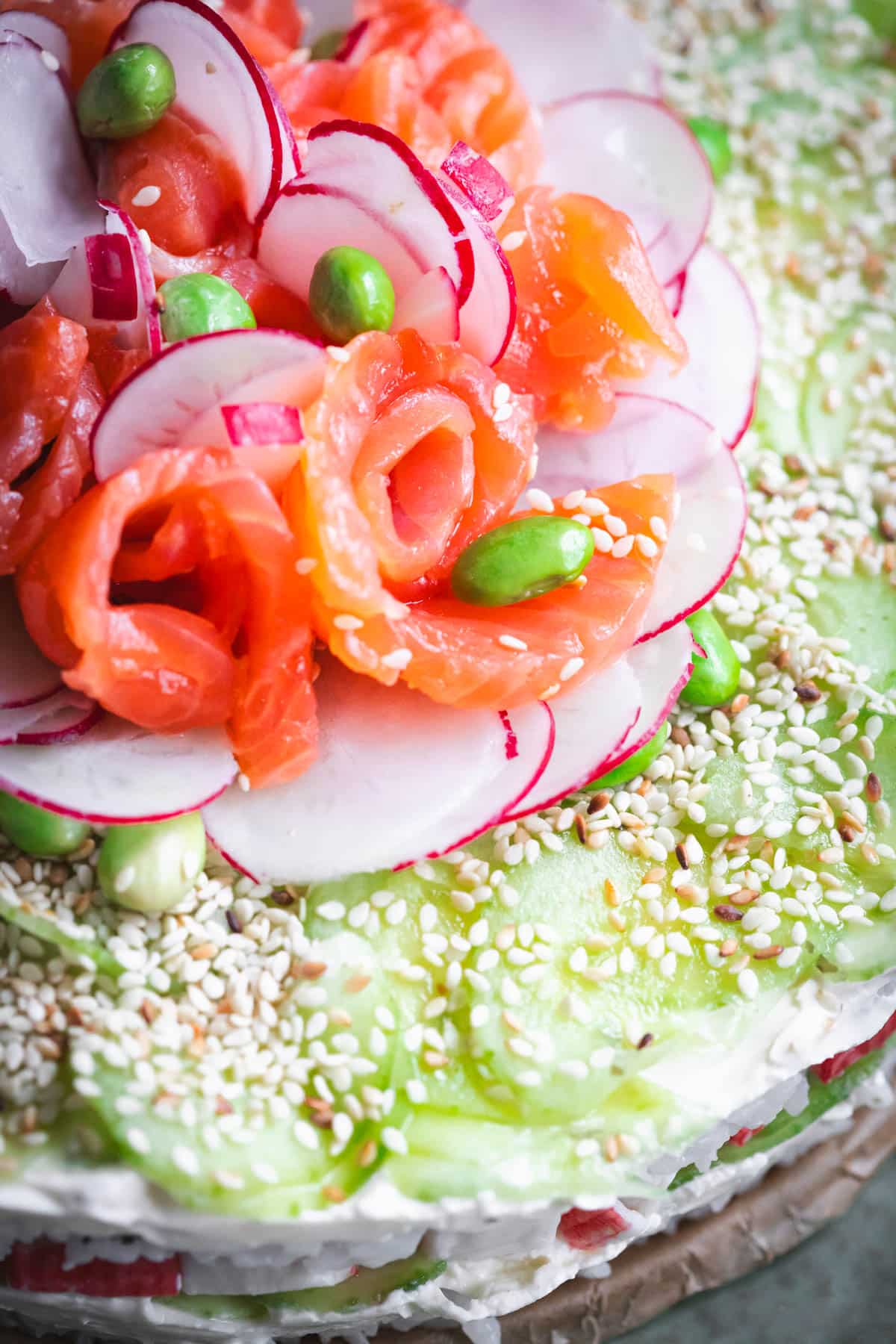 Salmon slices and radish slices on top of a cake.