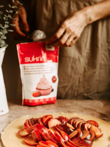 A package of sukrin sweetener with someone picking some of it with a sieve.