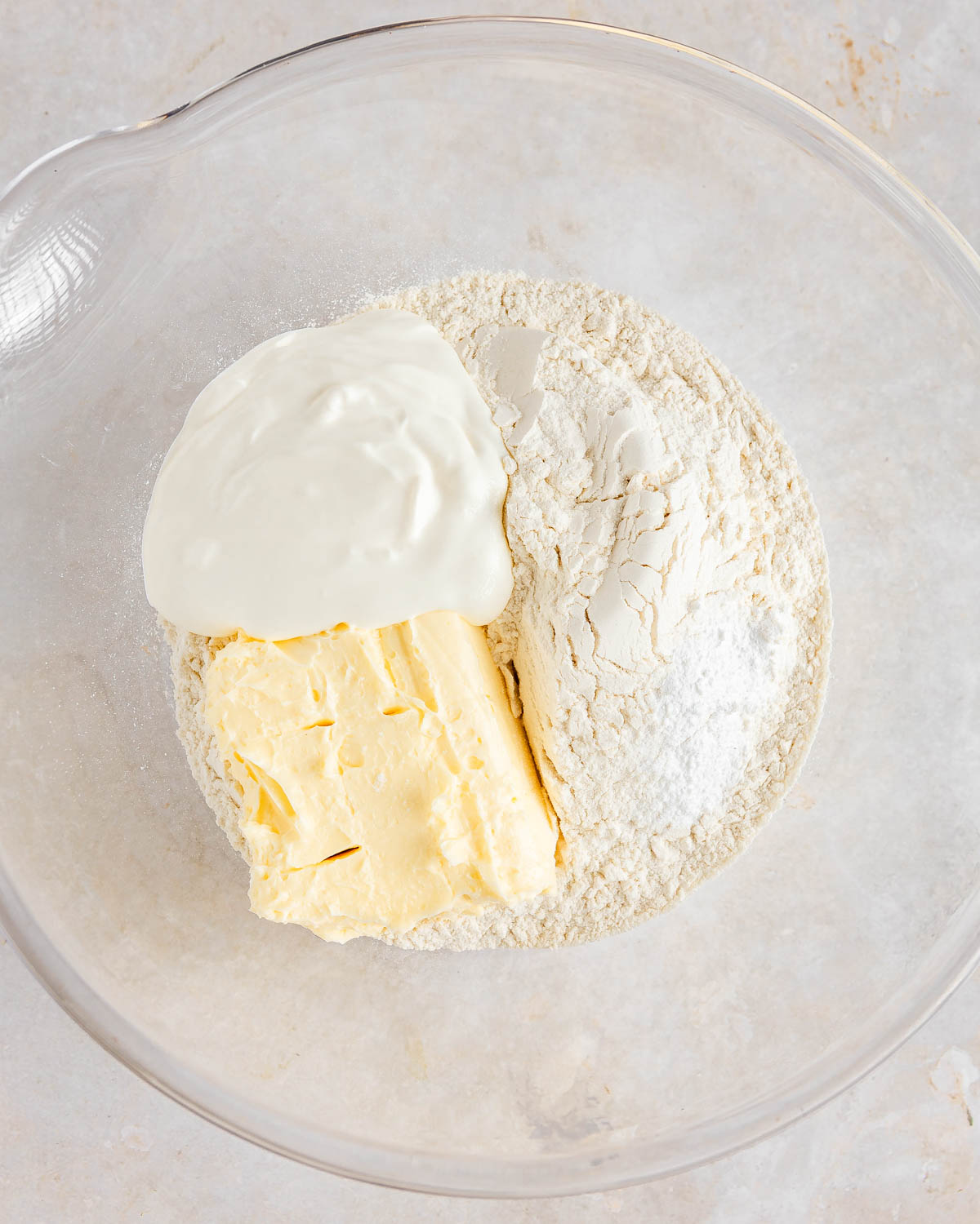 A transparent bowl with cake crust ingredients.