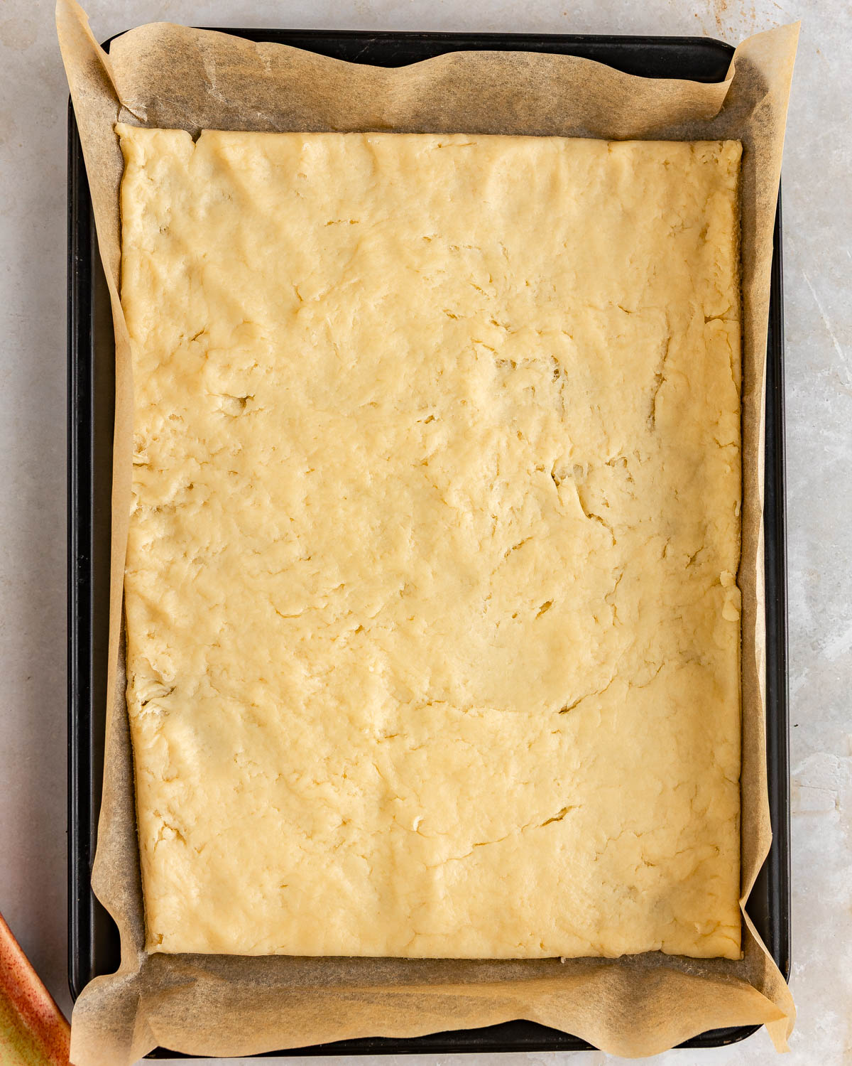 Dough placed into a sheet pan, lined with parchment paper.