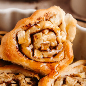 A closeup shot of a triangular-shaped apple cinnamon roll.