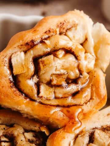 A closeup shot of a triangular-shaped apple cinnamon roll.