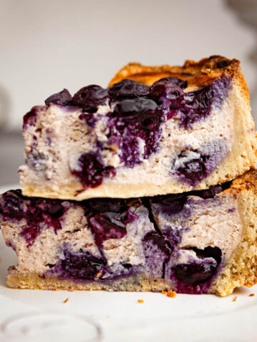 Stacked slices of blueberry sheet cake on a plate.