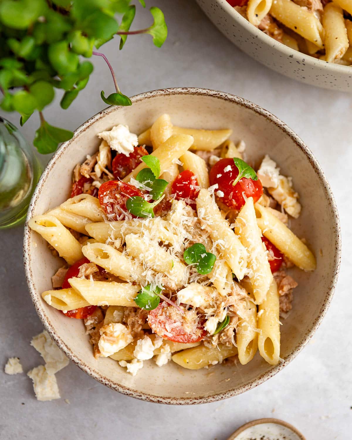 A top-down shot of a portion of tuna pasta salad on a light background.