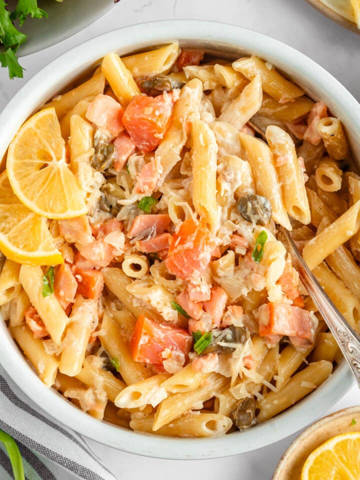 A top-down view on a round bowl with pasta salad with smoked salmon.