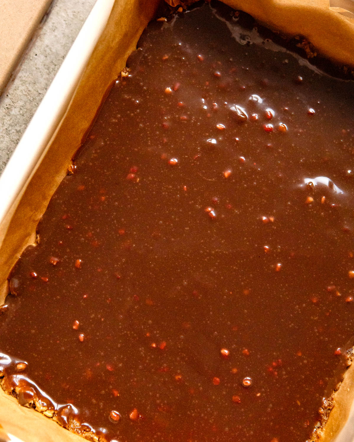 A process shot with a rectangular baking dish with sugar-free date barks.