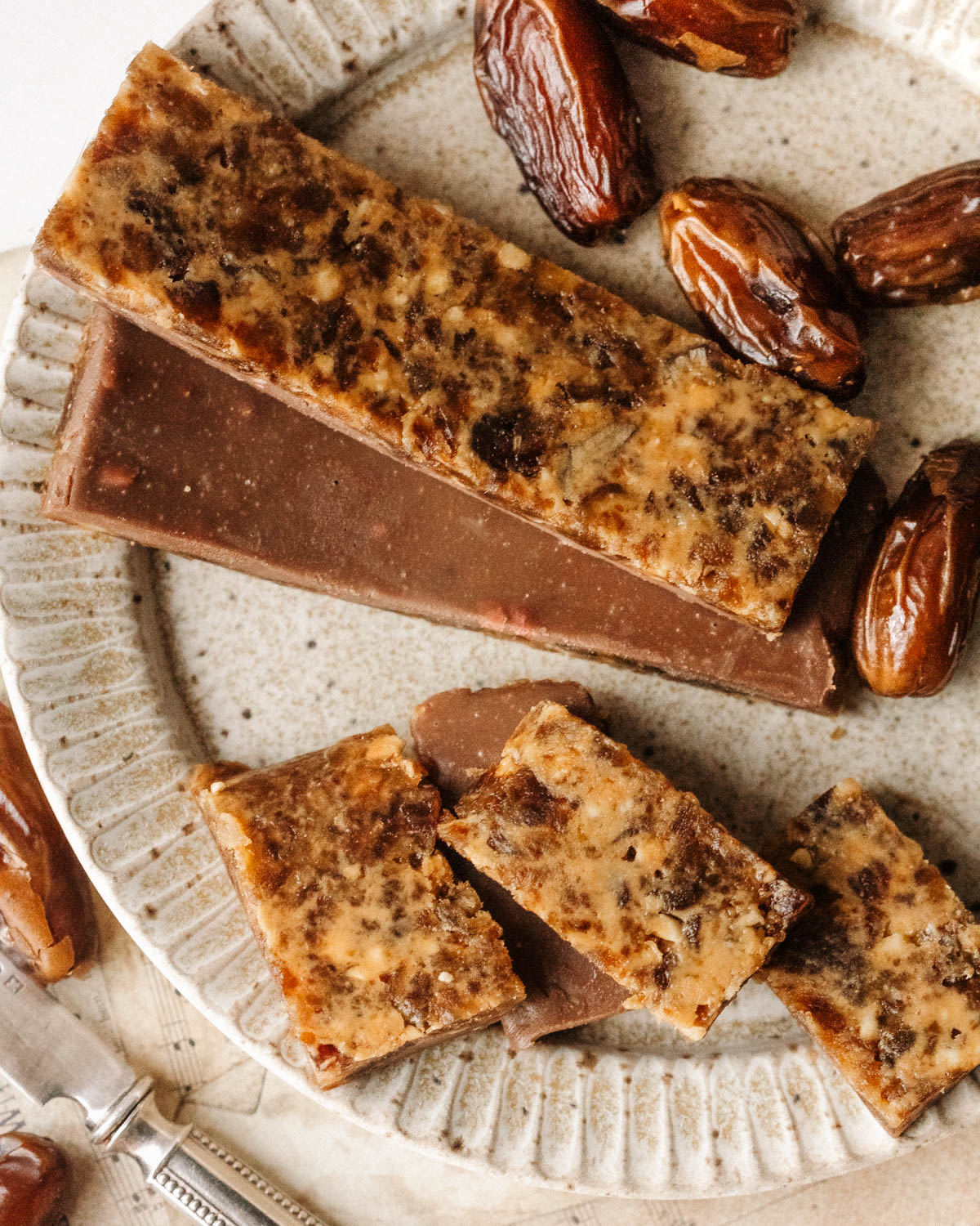 A top-down view of a plate with sugar-free date barks of different shapes and sizes.