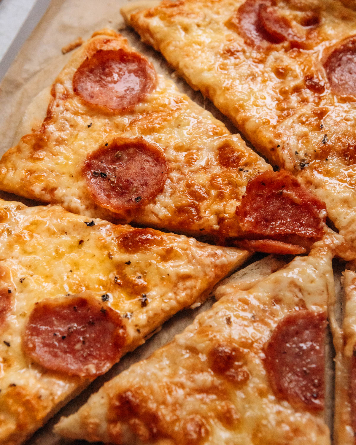 A sliced homemade pizza with cheese and pepperoni.