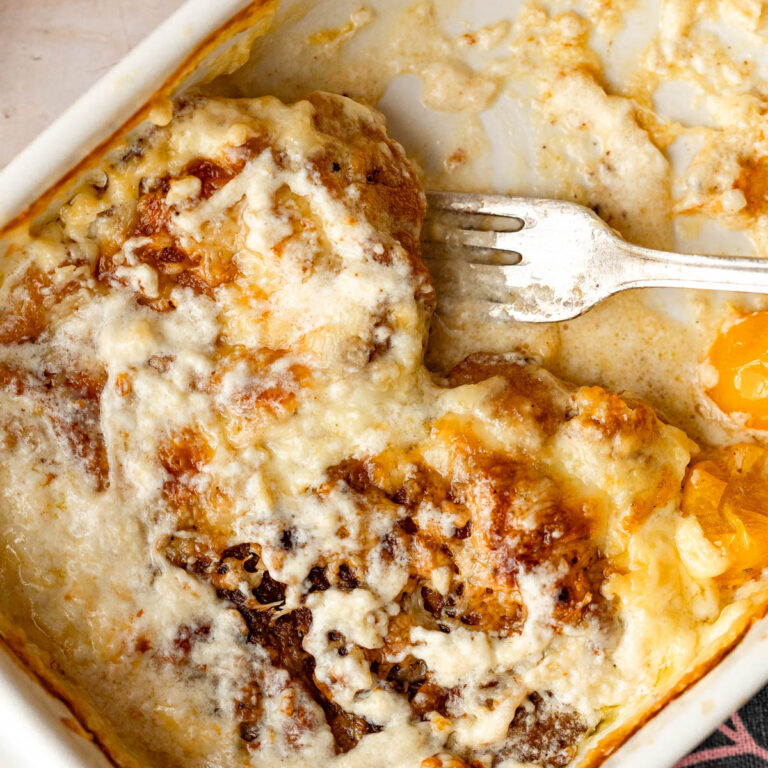 A baking pan with baked pork chops and tomatoes in a heavy cream sauce.