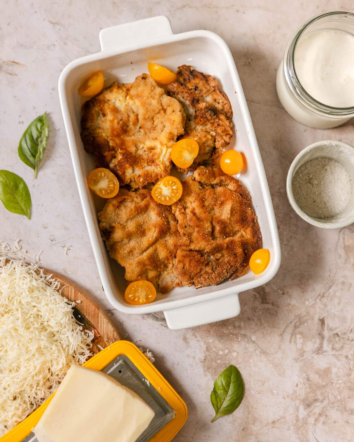 A top view of a one-pan pork chops layered in a baking pan with cherry tomatoes scattered.