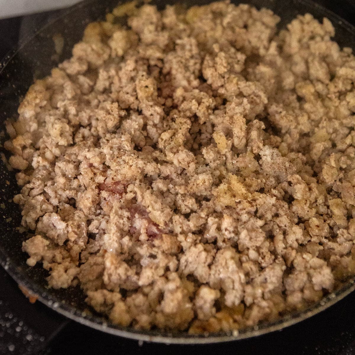 Minced meat being cooked in a skillet.